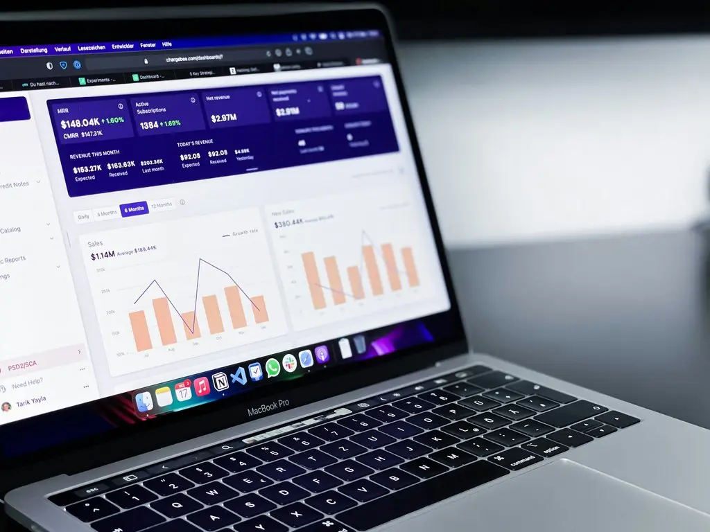 Laptop displaying procurement transformation dashboard with sales and revenue charts.