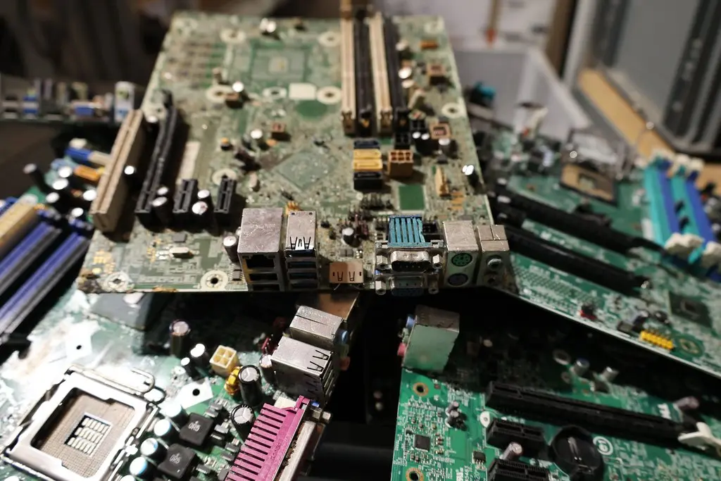 Pile of discarded computer motherboards, representing IT hardware waste.